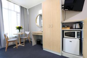 a room with a kitchen with a microwave and a table at Nebula Motel in Cooma