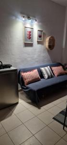 niebieską kanapę w salonie z poduszkami w obiekcie Cosy little studio for family vacations ! w mieście Rodos