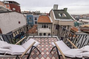 a balcony with chairs and a view of a city at Calanthe Residence in Istanbul