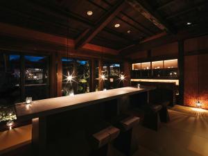a bar in a restaurant with a view of the city at Nazuna Obi Onsen Resort in Nichinan