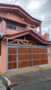a pink house with a gate in front of it at CERCA A TODO EN COSTA RICA in San Ramón