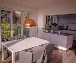 eine Küche mit einem weißen Tisch und einigen Stühlen in der Unterkunft Panoramahaus am Schlipfweg in Weil am Rhein