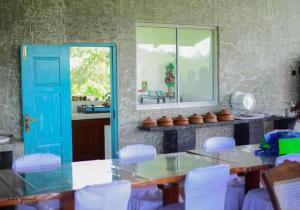 une cuisine avec une porte bleue, une table et des chaises dans l'établissement Luxury Rooms Cinnamon Nature Resort, à Beruwala