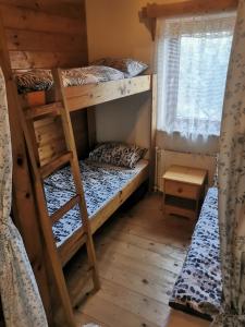 a room with two bunk beds and a window at chata u Tesáku in Rajnochovice