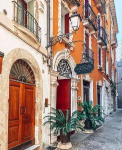 a building with a door and two plants in front of it at Antico Hotel Vicenza in Vicenza