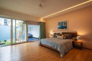 a bedroom with a bed and a large window at Isle View by VEO - Part of StayVista in Dabolim +22 photos