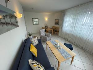 a living room with a blue couch and a table at Apartment Jette mit Balkon in Zempin