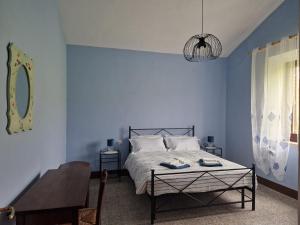 um quarto azul com uma cama e uma mesa em Agriturismo Rossello em San Quirico dʼOrcia