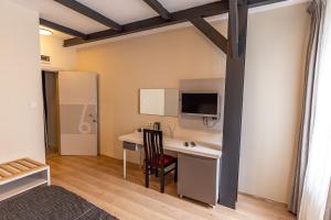a room with a desk with a computer and a tv at Calanthe Residence in Istanbul