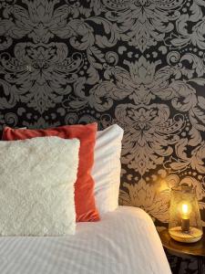 a bed with a pillow and a table with a lamp at Hotel Molengroet in Noord-Scharwoude