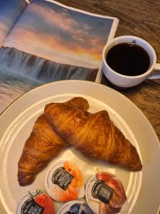 een bord croissants op een tafel met een kopje koffie bij Hotel Molengroet in Noord-Scharwoude