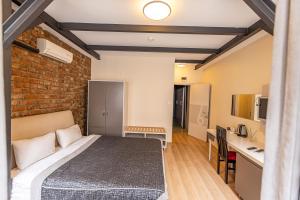 a bedroom with a bed and a brick wall at Calanthe Residence in Istanbul