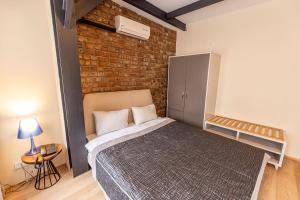 a bedroom with a bed with a brick wall at Calanthe Residence in Istanbul