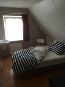 a bedroom with a bed and a window and a sink at Oans Thuus in Ballum