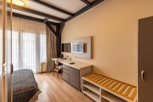 イスタンブールにあるカランセ レジデンスのデスクとベッドが備わるホテルルームです。