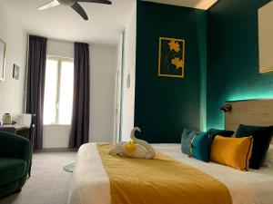 a bedroom with a bed with a stuffed animal on it at Hotel de France Citotel in Rochefort