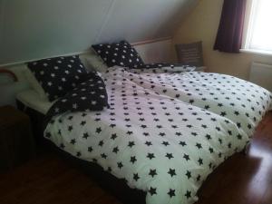 uma cama com lençóis e almofadas preto e branco em Oans Thuus em Ballum