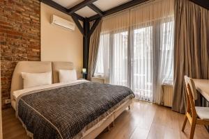 1 dormitorio con cama y pared de ladrillo en Calanthe Residence, en Estambul