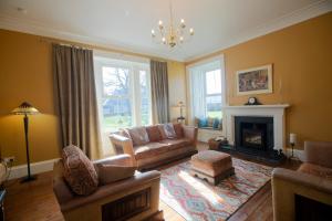 a living room with a couch and a fireplace at Cardhu Country House in Aberlour