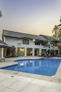 a large swimming pool in front of a house at Royal Bakoena Hamiltonparks Country Lodge in Hazyview