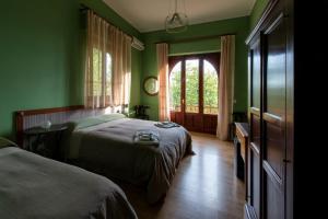 ein grünes Schlafzimmer mit 2 Betten und einem Fenster in der Unterkunft Domus Verdiana in Ragalna