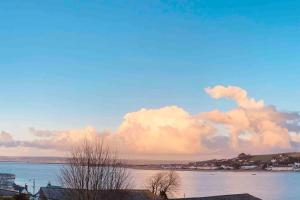 uma vista de um corpo de água com nuvens no céu em * Fisherman’s Cottage * with river views (dog friendly!) em Appledore