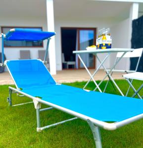 una cama elástica azul en la hierba con una mesa en Costa Santander. Apartamento con jardín en Santander