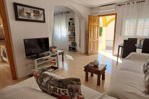 ein Wohnzimmer mit einem Sofa und einem TV in der Unterkunft Casa Marrón, Playa Flamenca in Playa Flamenca