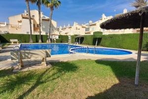 una piscina di fronte a un grande edificio di Casa Marrón, Playa Flamenca PF007 a Playa Flamenca
