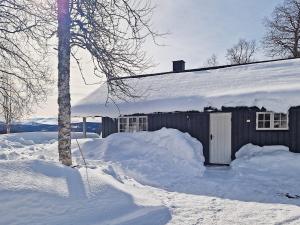 a house covered in snow with a pile of snow at 6 person holiday home in Nordli in Holand