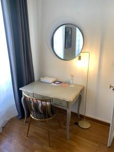 a desk with a mirror and a chair in a room at Escale citadine au centre d'Avignon, climatisation, appartement de charme, spacieux et lumineux in Avignon