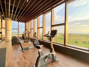 a gym with a row of exercise bikes in a room with windows at Bali Residence I B3105 Luxury 2BR I Seaview I 6-9pax l WaterPark I CityCentre by Jay Stay in Melaka