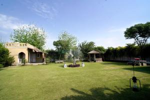 un patio con una casa con una palmera en 5 States Resort, en Amritsar