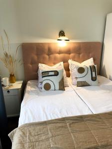 uma cama com lençóis brancos e almofadas em Spacious Supeluse Apartment em Pärnu