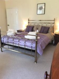 a bedroom with a bed with purple sheets at Rock Moor House B&B in North Charlton