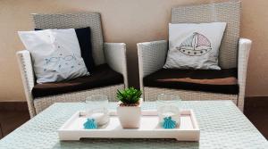 dwa wiklinowe krzesła z poduszkami i stół z tacą w obiekcie Apartment Old Town Starigrad Paklenica w mieście Starigrad-Paklenica