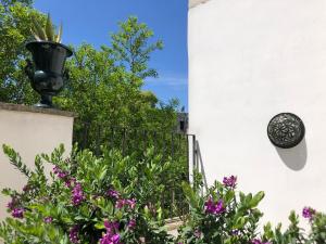 een tuin met paarse bloemen en een hek bij Antica Casa del Pozzo in Manduria