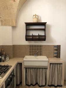 een keuken met een wastafel en een fornuis bij Antica Casa del Pozzo in Manduria