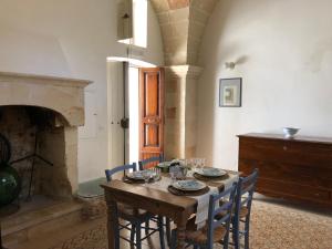 een eetkamer met een tafel en stoelen en een open haard bij Antica Casa del Pozzo in Manduria