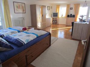 a bedroom with a large bed and a kitchen at Ferienwohnung Annalena in Seebruck