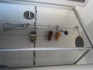 a shower stall with a shower head and tools at Ferienwohnung Annalena in Seebruck