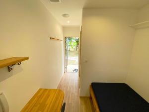 Habitación con cama, mesa y puerta en House&Cafe GreenTerrace, en Ishigaki Island