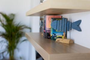 a shelf with books and a blue fish bookmark at The Nine Graces - Beach Apartment Clea, hot tub and sea views in Agia Anna Naxos