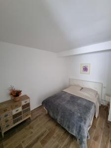 ein weißes Schlafzimmer mit einem Bett und Holzboden in der Unterkunft Appartement Premium in Beaulieu-sur-Mer