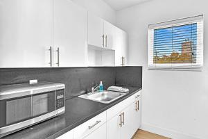 a kitchen with a sink and a microwave at Garden Suite 3-Hosted by Sweetstay in Miami Beach