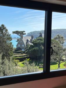een raam met uitzicht op een huis bij Nid de Pie in Crozon