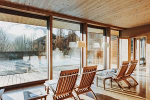2 Stühle in einem Wohnzimmer mit einem großen Fenster in der Unterkunft Hotel Post Bezau in Bezau