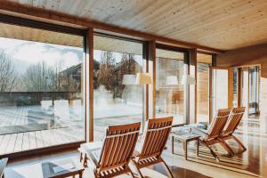 two chairs in a living room with a large window at Hotel Post Bezau in Bezau