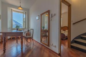 a dining room with a table and a mirror at Casa Ferrari in Varenna