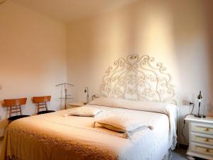 1 dormitorio con 1 cama blanca y 2 sillas en Appartamento vicino al centro di Olbia, en Olbia